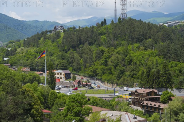 Panorama with mountains, forest, village, a flag and a road leading through the green landscape, view of Dilijan, Delijan, Delijan, Tavush province, Armenia
