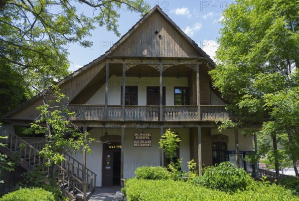 Traditional wooden house with veranda surrounded by green trees and natural ambiance, Old Town, Sharambeyan Street, Dilijan, Delijan, Delijan, Tavush Province, Armenia
