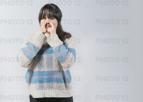 Asian woman covering nose because bad smells. Asian girl with a face from unpleasant odors. Concept of bad smells