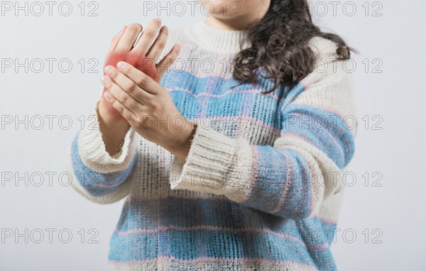 Closeup of woman with arthritis rubbing hands. Unhappy female suffering with pain hands isolated