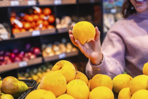 Woman selecting a ripe peach from the fresh produce section, highlighting healthy eating choices and grocery shopping experience in a supermarket aisle