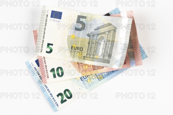 Stacked euro banknotes in denominations of 5, 10 and 20 on a white background