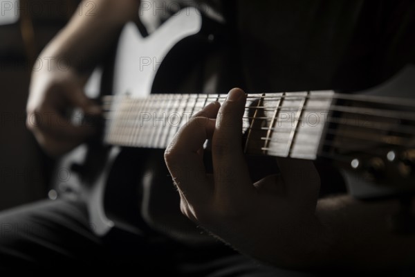 Close-up of a hand playing a guitar