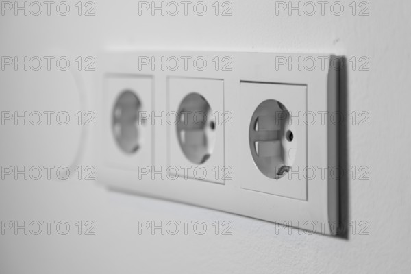 White triple outlet on a white wall