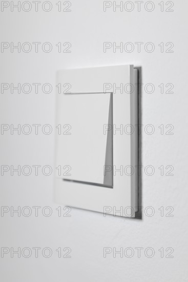 White light switch on a white wall, minimalistic design