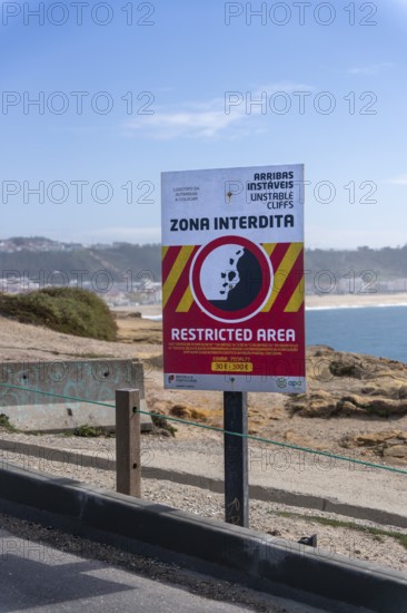 Sign with a warning about the cliff edge, Farol de Nazare, Portugal