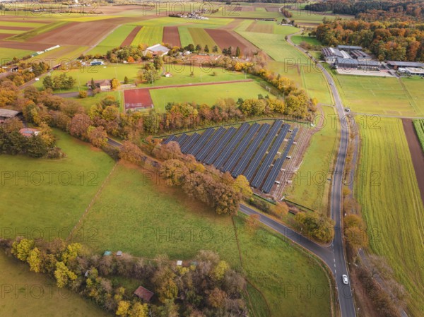 Extensive view of solar systems between fields and autumn trees, Bau PV Freifaechenanlage, Weil der Stadt, Germany