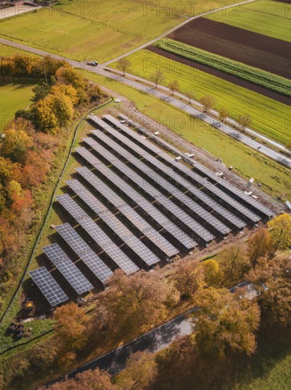 Solar field in autumn surroundings, surrounded by colorful trees and fields, from a bird's eye view, Bau PV Freifaechenanlage, Weil der Stadt, Germany
