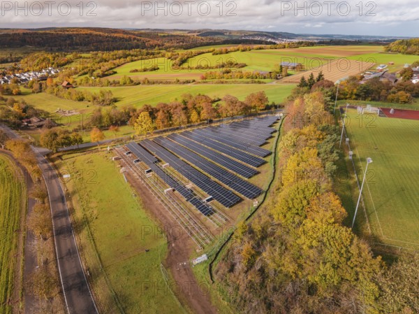 Large solar field in an autumn landscape, surrounded by green fields and trees, Bau PV Freifaechenanlage, Weil der Stadt, Germany