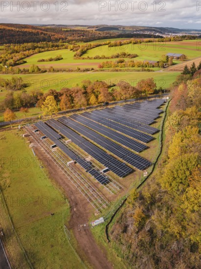 Aerial view of a large solar plant in an autumn landscape with fields and trees, PV Freifaechenanlage construction, Weil der Stadt, Germany