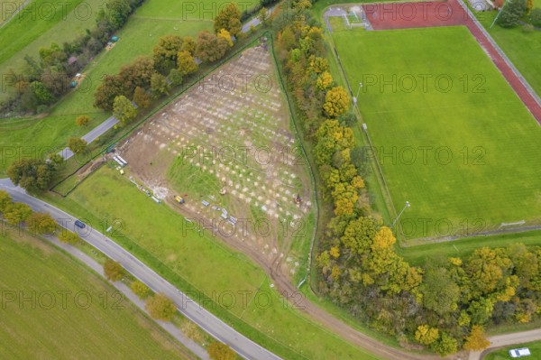 Aerial view of a large field next to a sports field, surrounded by autumn trees and roads, PV FreifÃ¤chenanlage building, Weil der Stadt, Germany