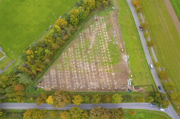 Aerial view of a field with construction next to a road surrounded by autumn trees, PV Freifaechenanlage building, Weil der Stadt, Germany