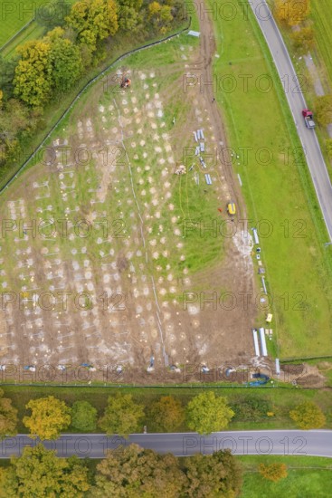 Aerial view of a large rectangular field with construction activities surrounded by autumn trees, PV Freifaechenanlage construction, Weil der Stadt, Germany