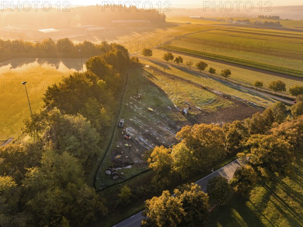 Wide landscape at sunrise, enlivened by autumn colors and soft light, PV Freifaechenanlage construction, Weil der Stadt, Germany