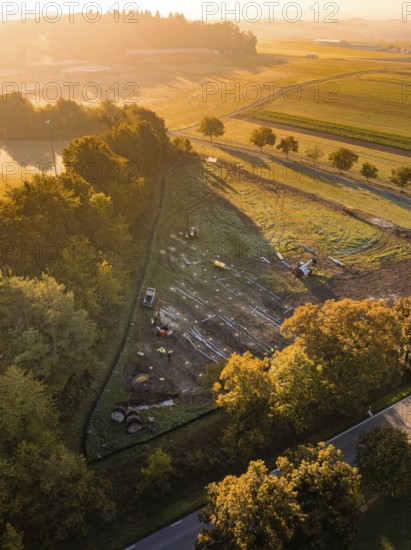Landscape during sunrise with construction activities in a field, Bau PV Freifaechenanlage, Weil der Stadt, Germany