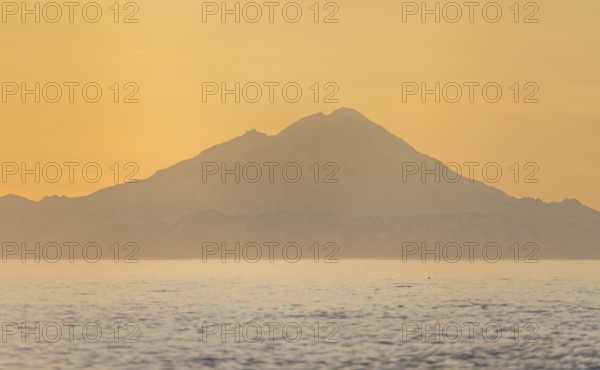 View of Cook Inlet on white mountain peaks of Mount Redoubt at sunset, midnight sun, Aleutian mountains, Anchor Point, Anchor River State Recreation Area, Alaska, USA