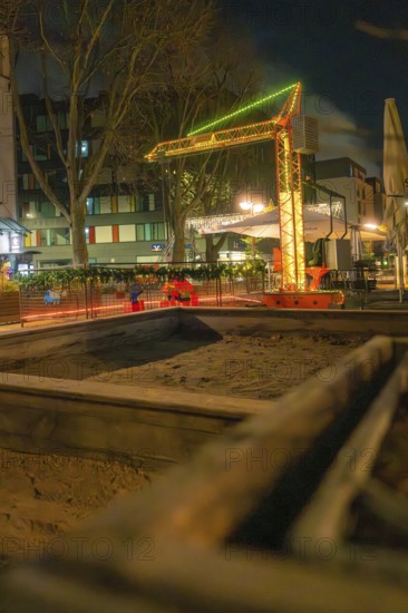 Evening street scene with illuminated construction crane and surrounding buildings, Sindelfingen, Böblingen district, Germany