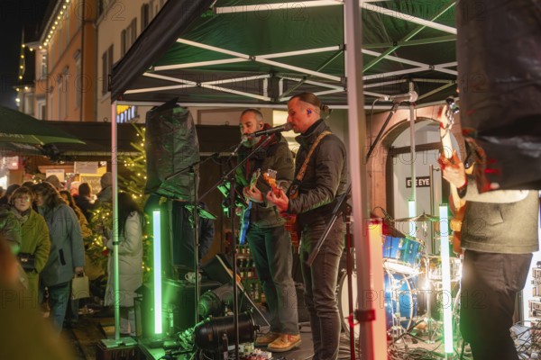 Live music performance on a stage in a festively illuminated market, Christmas market 2025, Nagold, Black Forest, Calw district, Germany
