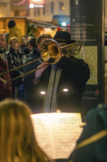 Musician plays trombone at an evening concert in a festive setting, Christmas market 2025, Nagold, Black Forest, Calw district, Germany