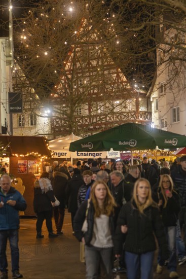 People stroll through a well-visited, festively lit Christmas market, Christmas market 2025, Nagold, Black Forest, Calw district, Germany