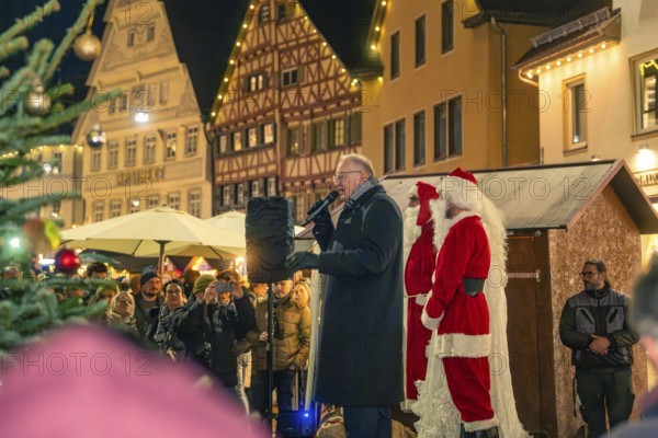 A man gives a speech next to Santa Claus on a market square with half-timbered houses, Christmas market 2025, Nagold, Black Forest, Calw district, Germany
