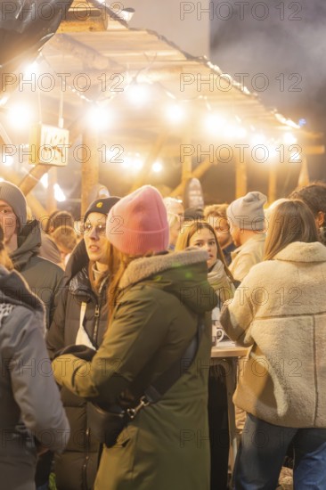 Sociable people in winter clothes at an atmospheric Christmas market, Christmas market 2025, Nagold, Black Forest, Calw district, Germany