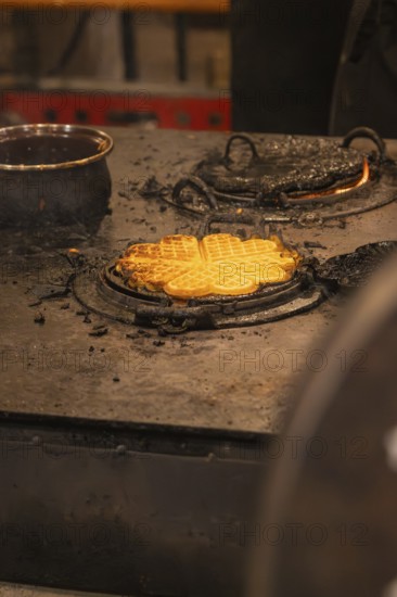 Freshly baked waffles on a hot iron in a Christmas setting, Christmas market 2025, Nagold, Black Forest, Calw district, Germany