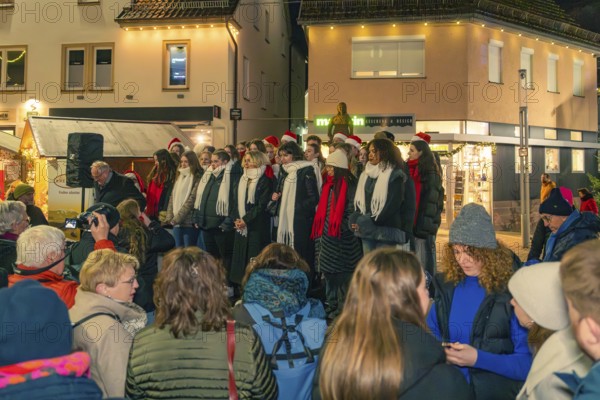 A choir sings on a busy street in front of an audience in wintry weather, Christmas market 2025, Nagold, Black Forest, Calw district, Germany