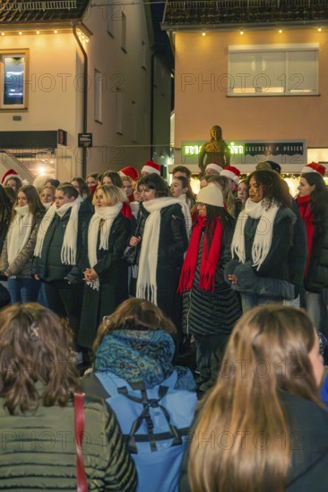 Choir sings in the evening in a Christmas atmosphere, surrounded by spectators, Christmas market 2025, Nagold, Black Forest, Calw district, Germany