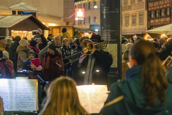 Street musicians play outdoors on a busy shopping street at night, Christmas market 2025, Nagold, Black Forest, Calw district, Germany