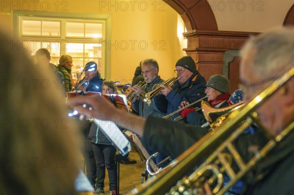 Musicians playing brass instruments indoors with winter clothes, Christmas market 2025, Nagold, Black Forest, Calw district, Germany