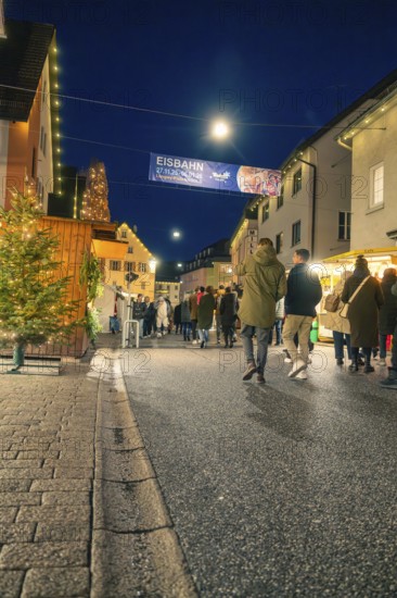 People stroll at night through an illuminated pedestrian zone with a festive atmosphere, Christmas market 2025, Nagold, Black Forest, Calw district, Germany