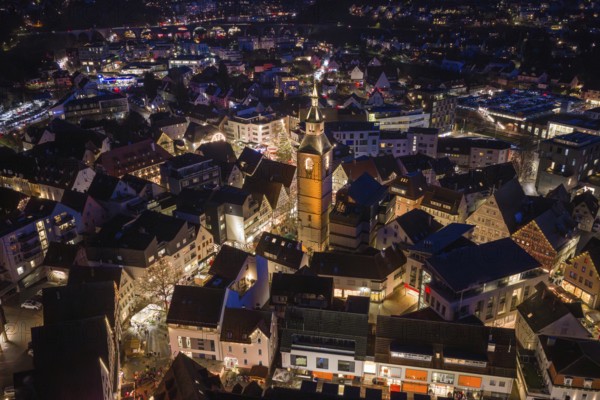 Aerial view of an illuminated city at night dominated by a large church surrounded by festively illuminated houses, Christmas market 2025, Nagold, Black Forest, Calw district, Germany