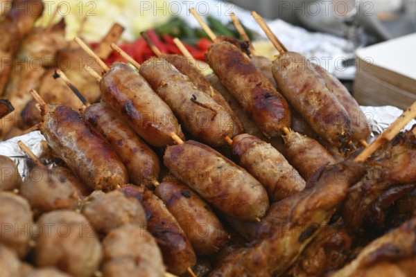 Thai 'Sai Krok Isaan' pork sausages on skewers at street food market