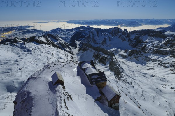 Night view, long exposure from 2506 meter high SÃ¤ntis down to the mountain gas houses of Alter SÃ¤ntis and the wintry, snow-covered Swiss and Austrian Alps, during a clear full moon night, Canton of Appenzell, Switzerland