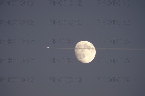 Airplane and moon, winter evening, Germany