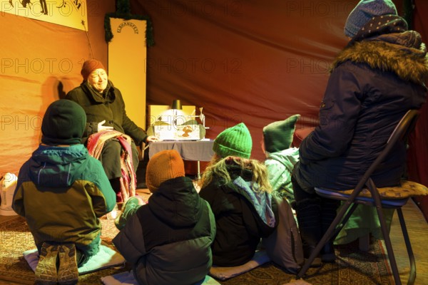 Storyteller with children at the Elbhangfest Christmas market in Dresden Loschwitz in the historic village center of Loschwitz during Advent, Dresden, Saxony, Germany