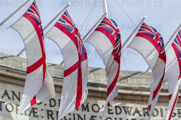 The Admiralty Arch decorated with the flags of the Royal Navy's White Ensign, London England, Great Britain