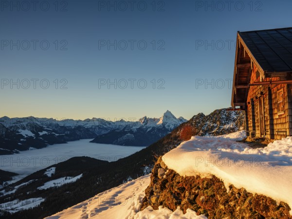 Alpine hut in winter at morning light, behind the Watzmann, fog in the valley, Berchtesgaden Alps, Scheibenkaser, Marktschellenberg, Berchtesgadener Land, Upper Bavaria, Bavaria, Germany