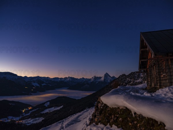 Alpine panorama in winter with Watzmann and alpine hut under starry sky at dawn, fog in the valley, Berchtesgaden Alps, Scheibenkaser, Marktschellenberg, Berchtesgadener Land, Upper Bavaria, Bavaria, Germany