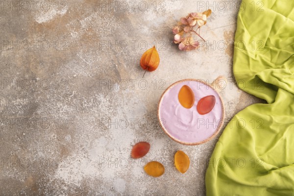 Purple Yogurt, with jelly candy on brown concrete background and green textile, top view, flat lay, copy space, minimalism