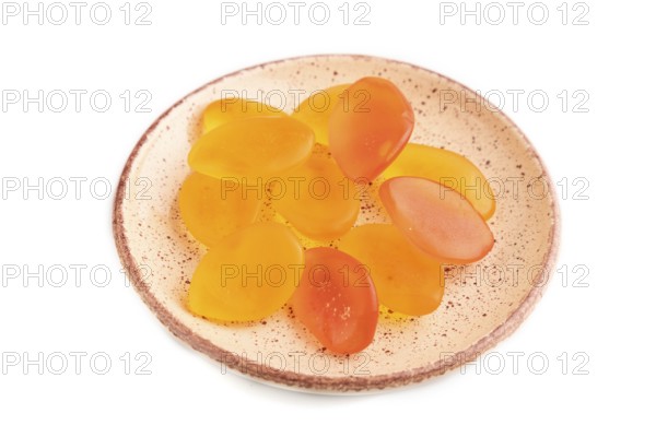 Jelly candies on ceramic plate isolated on white background, side view, close up
