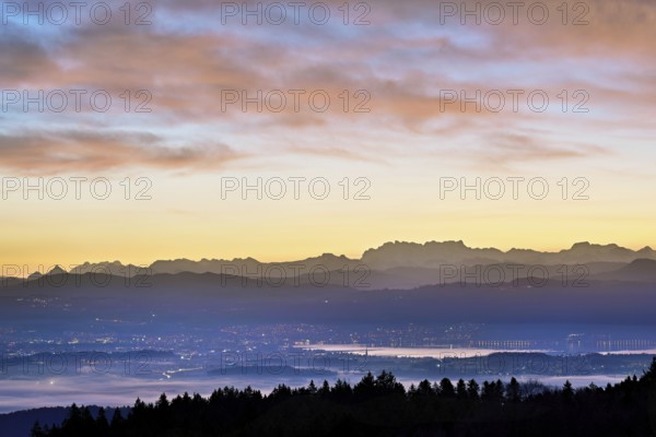 View from Horben of Lake Zug with the town of Cham and Zug, behind it the snow-capped mountains FlÃ¼brig and VrenelisgÃ¤rtli in the light of dawn, Beinwil-Freiamt, Canton, Aargau, Switzerland