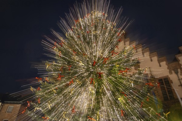 The lights of the Mrs Holle Christmas tree at the Frankfurt Christmas market glow in the evening. (Zoom effect by changing the focal length during long exposure), Römerberg, Frankfurt am Main, Hesse, Germany