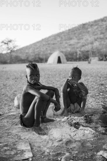 Black and white, Himba children at the fire early in the morning, traditional Himba village, Kaokoveld, Kunene, Namibia