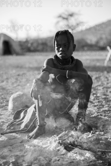 Black and white, Himba child at the fire early in the morning, traditional Himba village, Kaokoveld, Kunene, Namibia