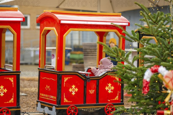 A child on a Christmassy decorated miniature train at a Christmas market, Sindelfingen, Böblingen district, Germany