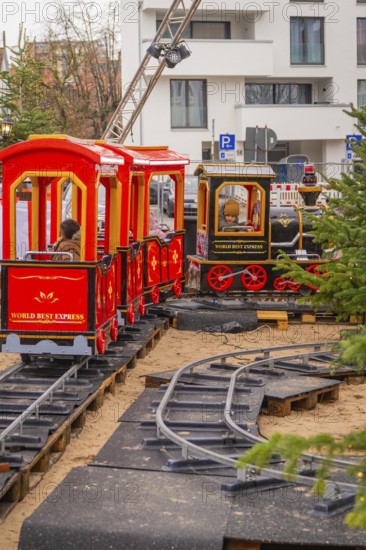 Two children on a toy train ride on an outdoor mini rail track, Sindelfingen, Böblingen district, Germany