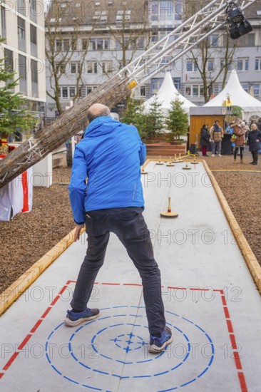 Man wearing a blue jacket aims at a marker while curling, Sindelfingen, Böblingen district, Germany
