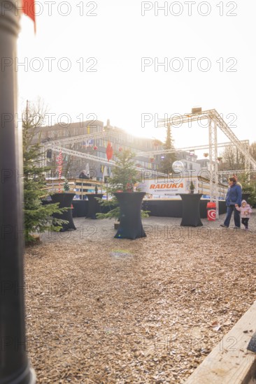 An urban marketplace with tables and people in a wintry atmosphere in sunlight, Sindelfingen, Böblingen district, Germany